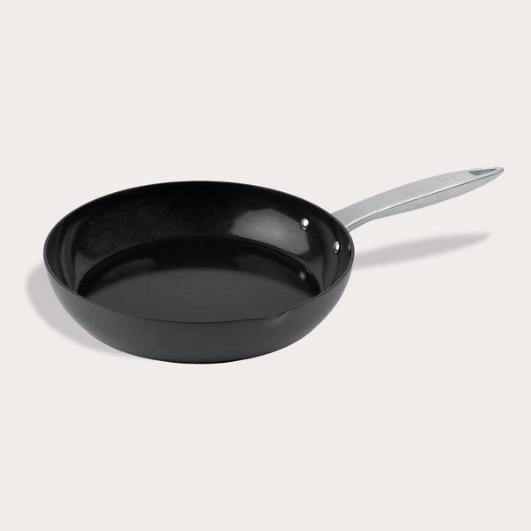 The Zyliss Ultimate Pro Ceramic Fry Pan, made from recycled aluminum, features a black non-stick surface and a sleek silver handle. Shown empty on a plain light background, the pan is displayed from an angled top view. #24cm/9½"