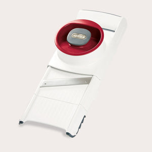 The Zyliss 4-in-1 Slicer & Grater in white and red, with a stainless steel blade and hand guard, sits on a light backgroundâ€”ideal for fast slicing or grating in any kitchen. 