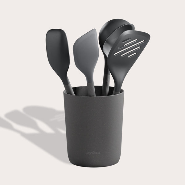 The Zyliss 5-Piece Utensil Set includes dark gray spatulas and serving spoons in a matching holder. All tools are dishwasher safe, making this set perfect for any modern kitchen. 