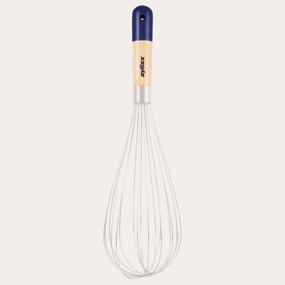 The Zyliss Beech Wood Balloon Whisk has stainless steel wires, a beech wood handle with a blue tip, small hanging hole, and printed logo. Shown on a plain white background. 