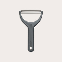 The Zyliss Wide Peeler features a Y-shaped design, ergonomic handle, and horizontal stainless steel blade, shown against a simple light background. 