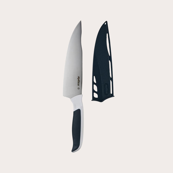 The Zyliss Comfort Chefs Knife 18.5cm / 7¼ with an ergonomic handle and stainless steel blade is displayed next to a black blade cover on a plain light background. 