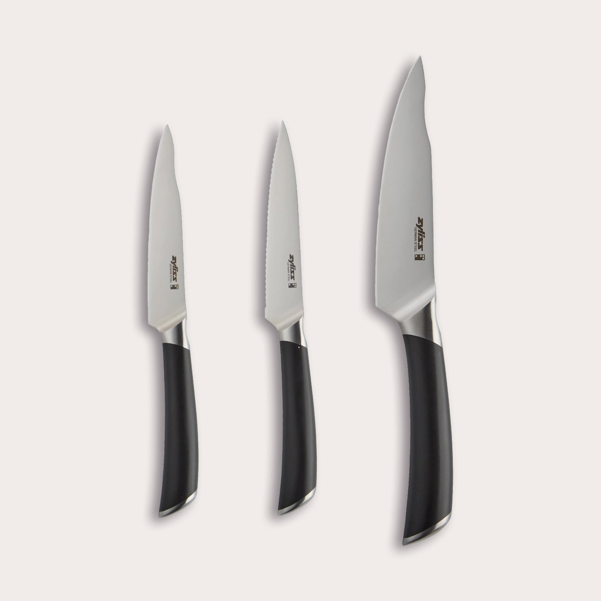 The Zyliss Comfort Pro 3 Piece Paring Knife & Utility Knife Set includes three kitchen knives with ergonomic black handles and German stainless steel blades: a paring knife, a serrated utility knife, and a chef’s knife. 
