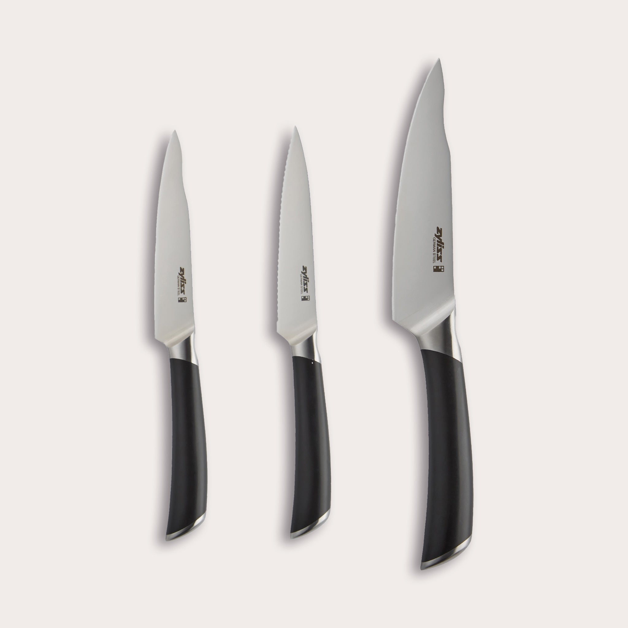 The Zyliss Comfort Pro 3 Piece Paring Knife & Utility Knife Set includes three kitchen knives with ergonomic black handles and German stainless steel blades: a paring knife, a serrated utility knife, and a chef’s knife. 