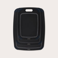 The Zyliss Wood Fibre Cutting Boards set features three nested black boards in different sizes, each with a handle slot and dark gray corner grips, made from eco-friendly recycled wood fibres and shown on a light background. #set of 3