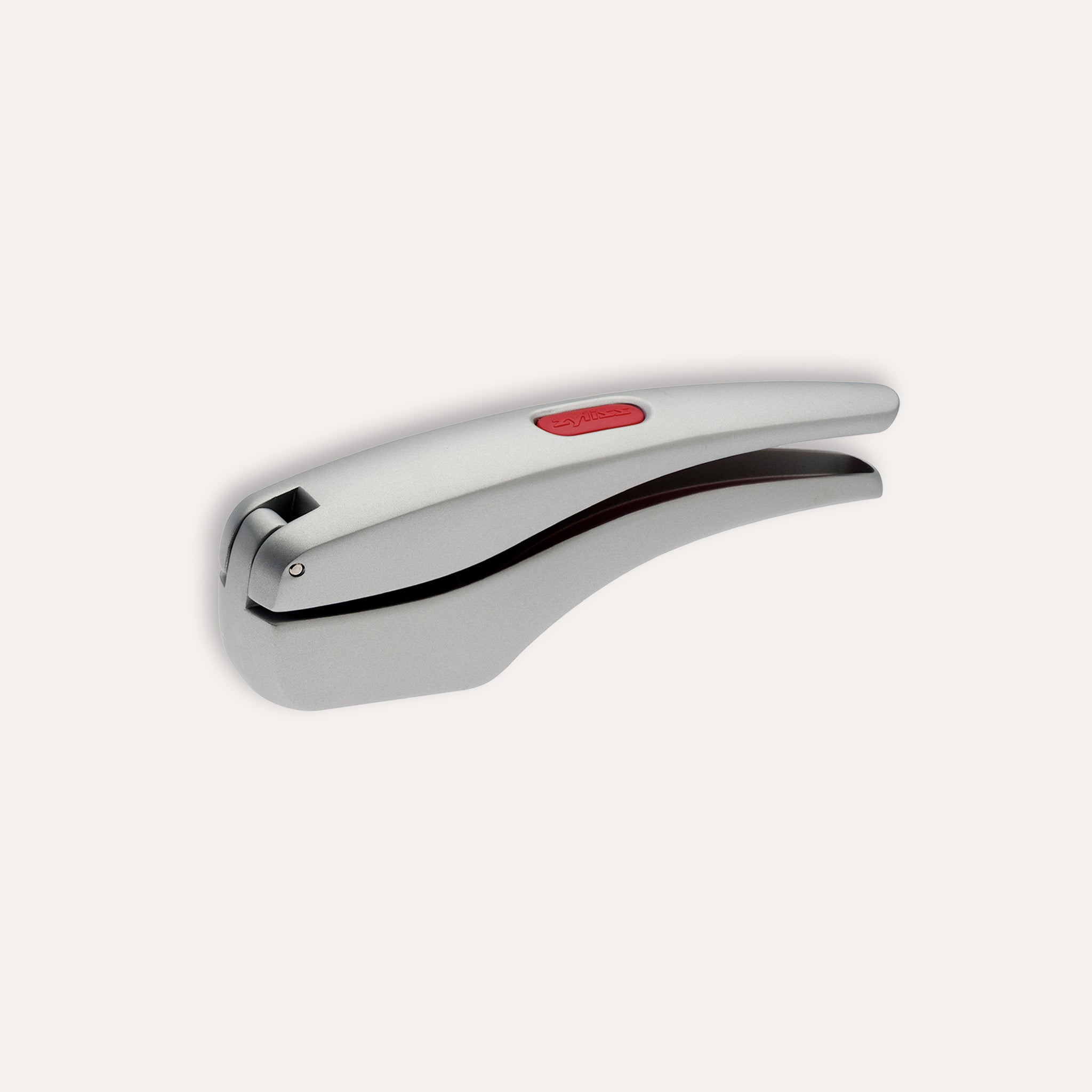 The Zyliss Susi 3 Garlic Press, made of stainless steel with an ergonomic handle and red accent, is shown closed on a white background. Itâ€™s dishwasher safe for easy cleaning. 