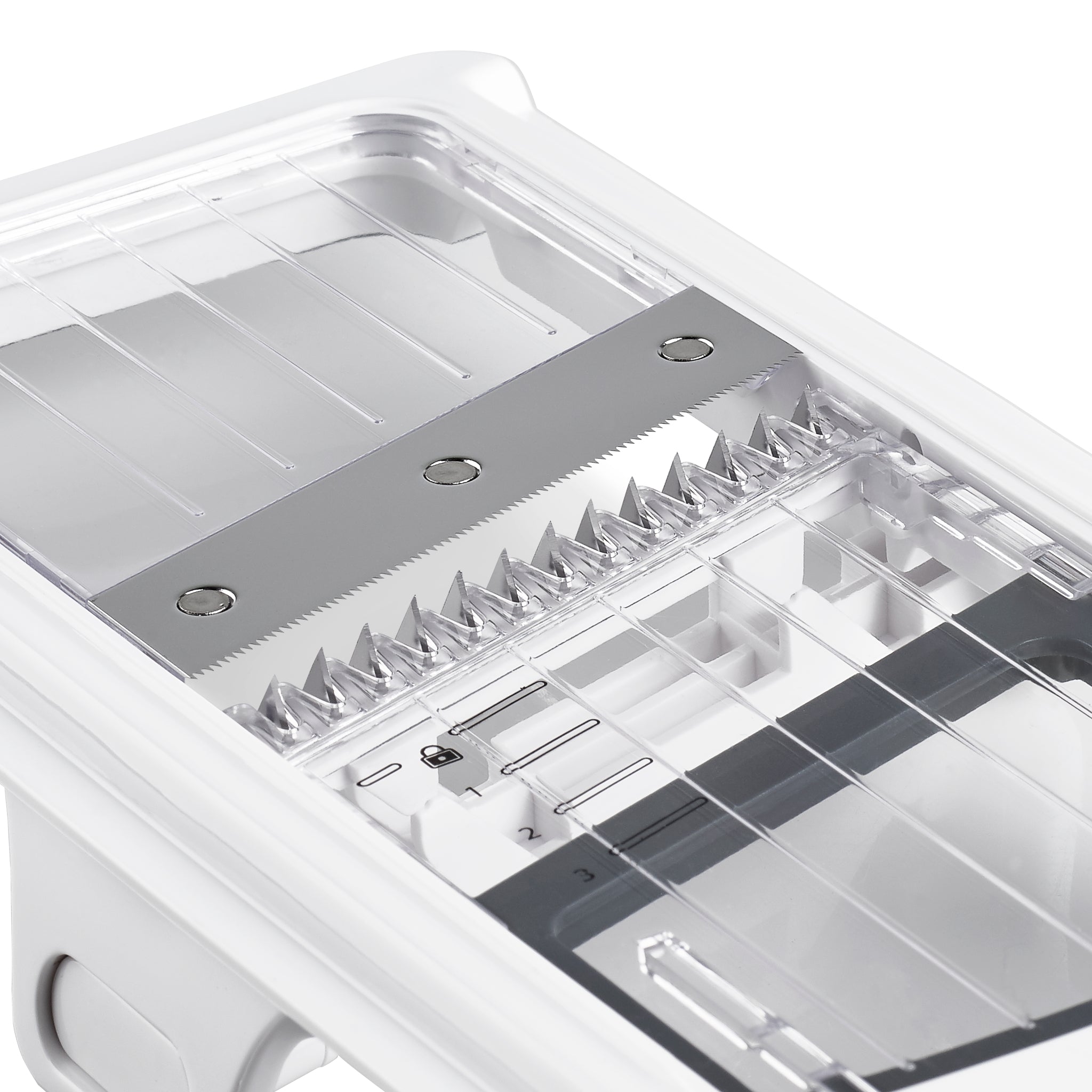 Close-up of a white and silver kitchen mandoline slicer with sharp metal blades, clear plastic guard, and adjustable thickness settings for slicing vegetables.