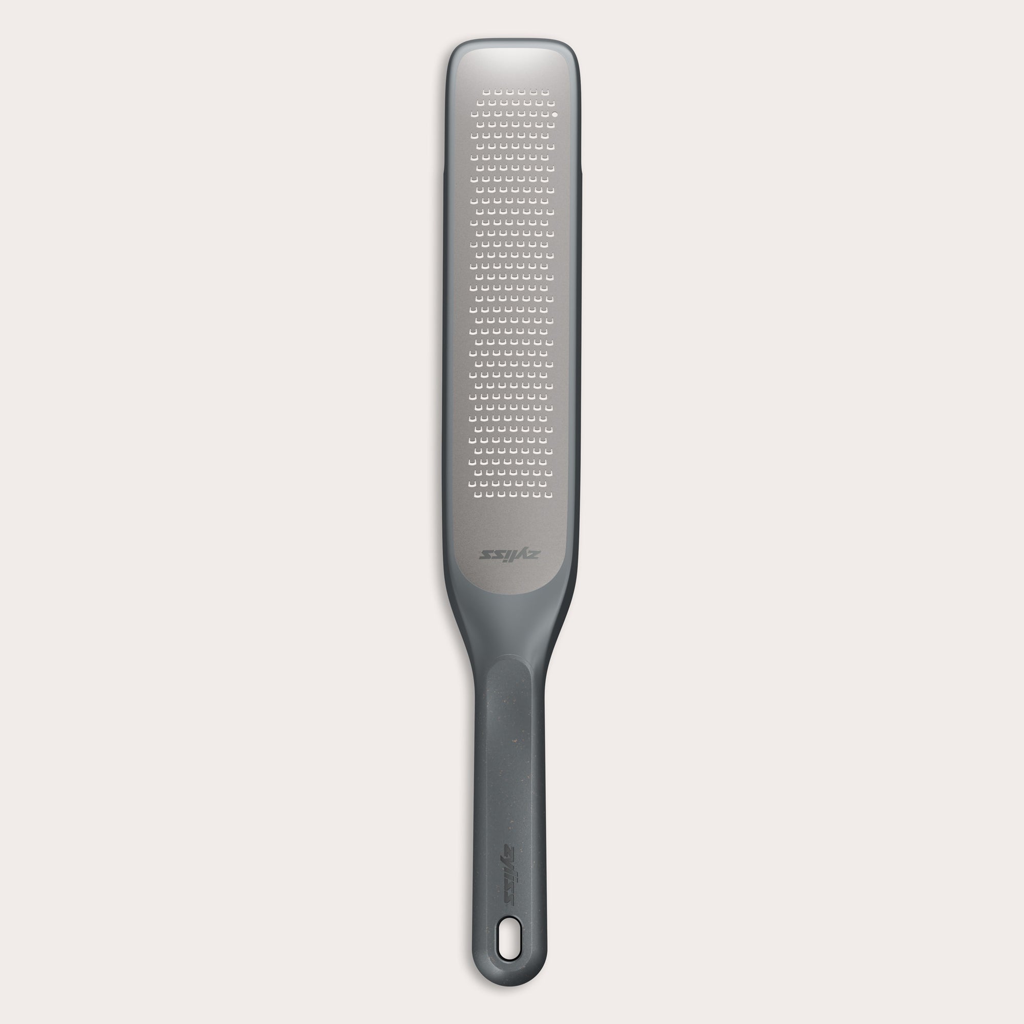 #belugagrey The Zyliss Rasp Grater is a long, rectangular foot file with a gray handle and textured metal surface for removing calluses and dead skin. The handle features a hanging hole for easy storage.