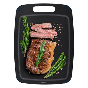 A cooked steak, sliced and garnished with rosemary and coarse salt, is served on a Zyliss Wood Fibre Cutting Board, made from recycled wood fibres. #Large