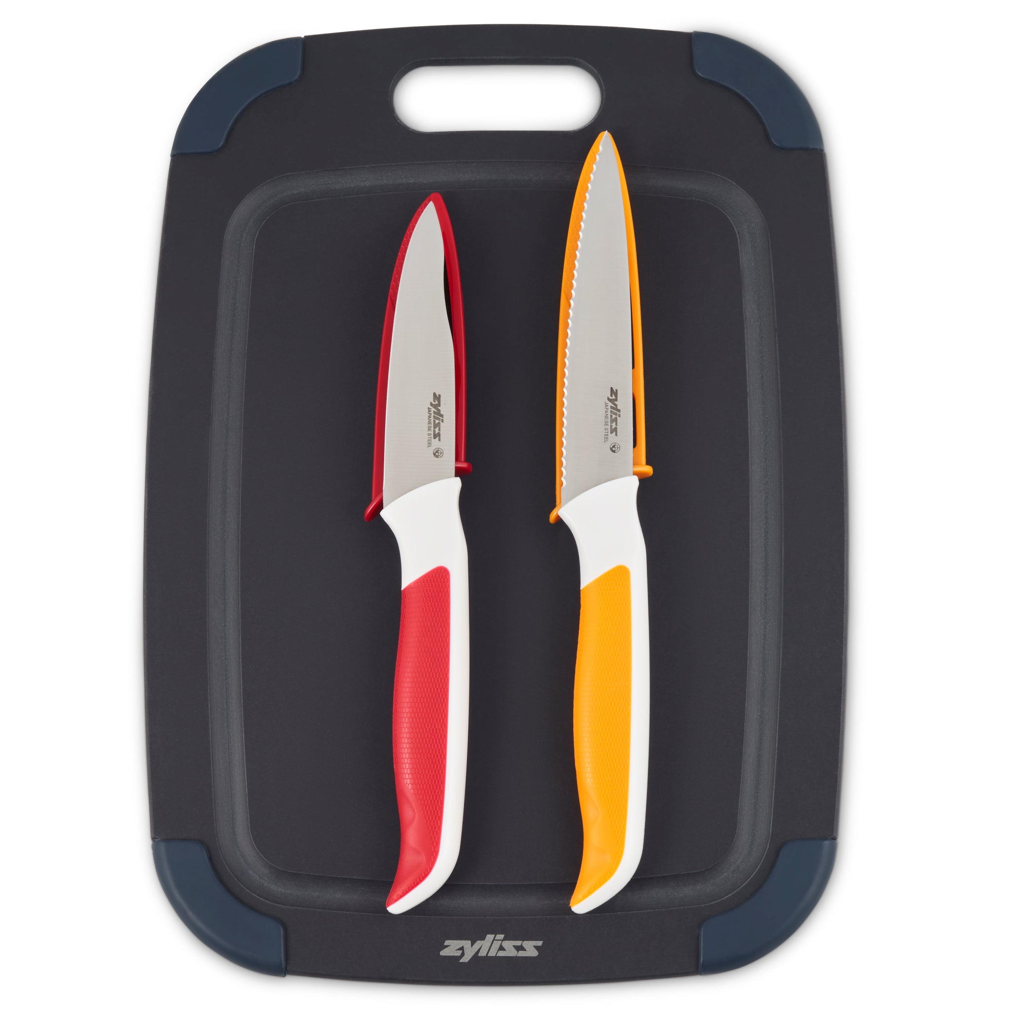 A black cutting board with a handle, featuring two kitchen knives with white handles—one with a red grip and blade, the other with an orange grip and serrated blade.