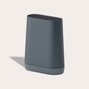 The Zyliss Universal Knife Block is a modern, dark gray block with rounded edges and a subtle speckled texture. It stands upright and features a flexible bristle insert for easy knife storage.