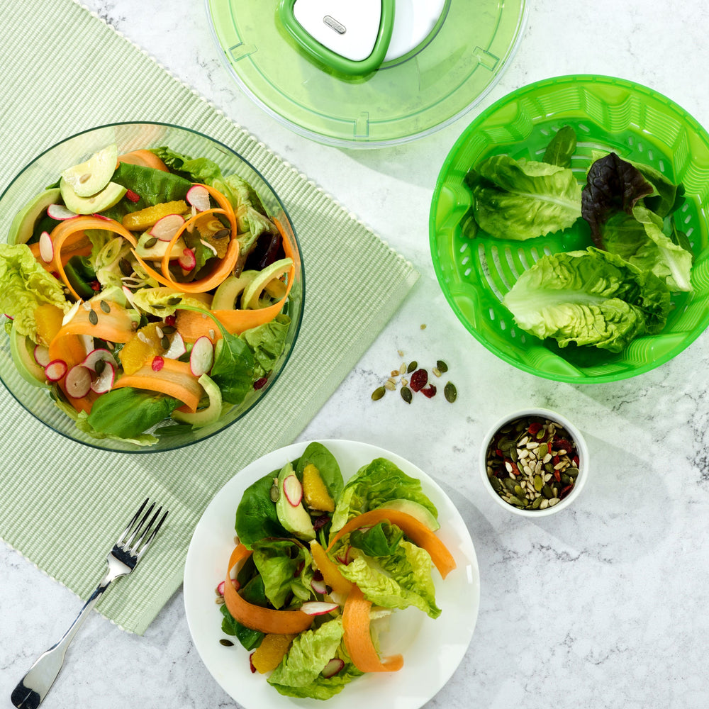 The Zyliss Easy Spin 2 Salad Spinner Small is green and transparent with a compact design, featuring a white button and handle on top, shown from above against a plain light background. 