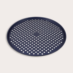 The Zyliss Durable Non-Stick Pizza Tray is a round, dark blue metal tray with raised edges and a perforated base featuring evenly spaced holes for optimal baking, shown against a plain light background.