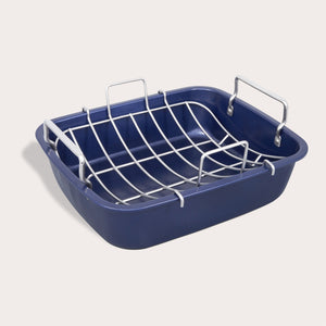 The Zyliss Durable Non-Stick Roasting Pan features a blue rectangular design with two side metal handles and a removable metal rack, all crafted from sturdy carbon steel and shown on a plain light background. 