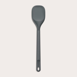 #large A Zyliss Spoontula with a dark gray, rounded silicone head and a long ergonomic handle, featuring a small hanging hole near the end, is displayed against a light background. #Large