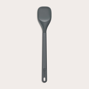 #medium The Zyliss Spoontula is dark gray, with a silicone head, long ergonomic handle, and a gently rounded rectangular bowl, pictured on a plain light background. #Medium