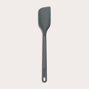 A dark gray Zyliss Spatula with a silicone head, curved flexible blade, and long handle with a hanging hole is shown on a plain light background. #Medium
