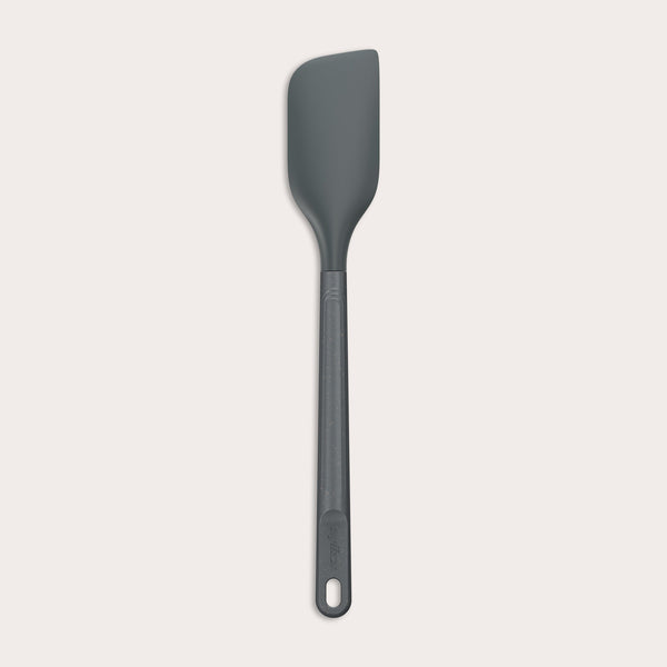 A dark gray Zyliss Spatula with a silicone head, curved flexible blade, and long handle with a hanging hole is shown on a plain light background. #Medium