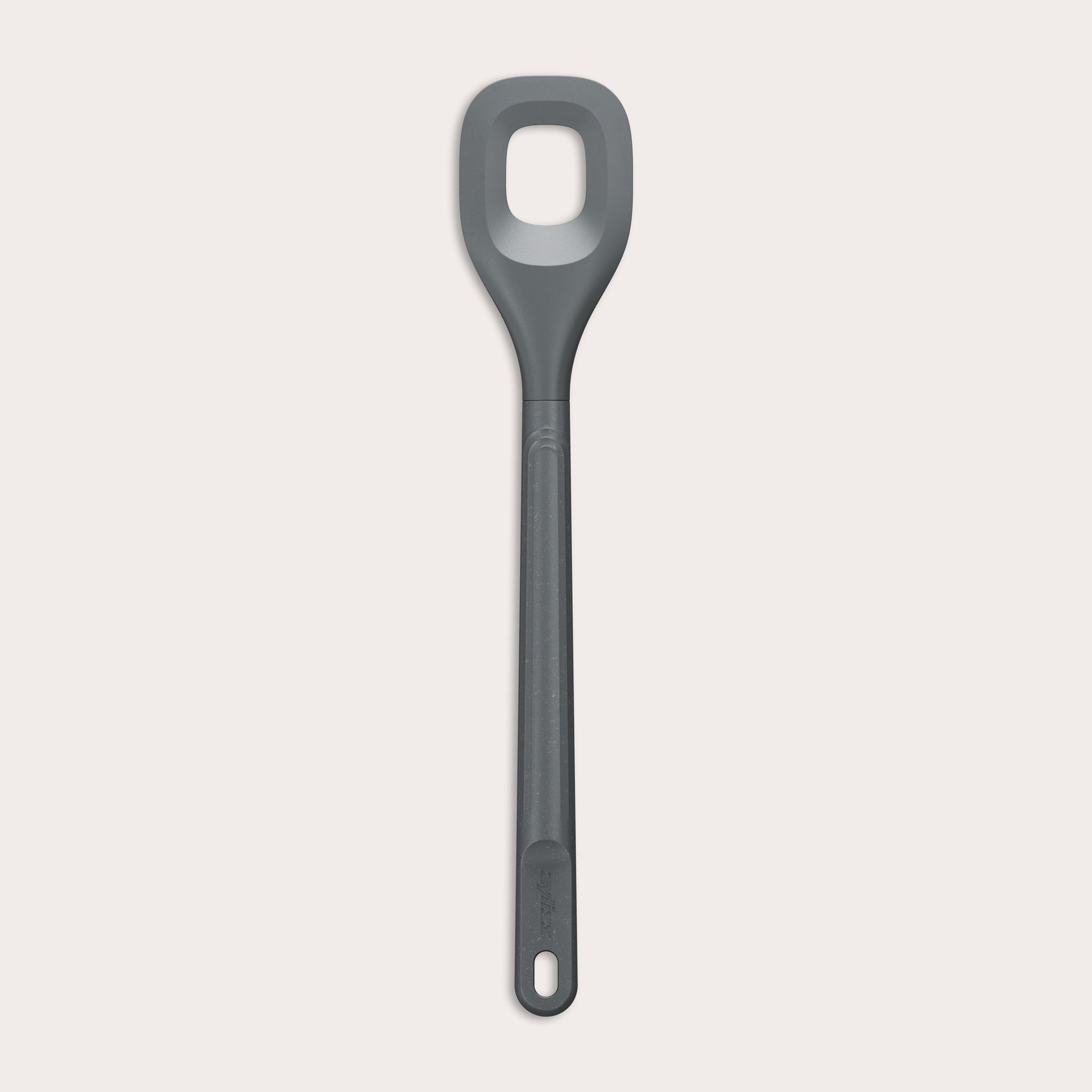 The Zyliss Square Mixing Spoon is a gray, heat-resistant silicone utensil with a long handle and a rectangular hole in the head. Shown on a plain light background, its dishwasher safe for easy cleaning. 