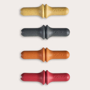 The Zyliss Corn Holders 4 Piece Set features cylindrical holders with ergonomic handles in yellow, black, orange, and red, each with a notch at one end, shown vertically on a light background.