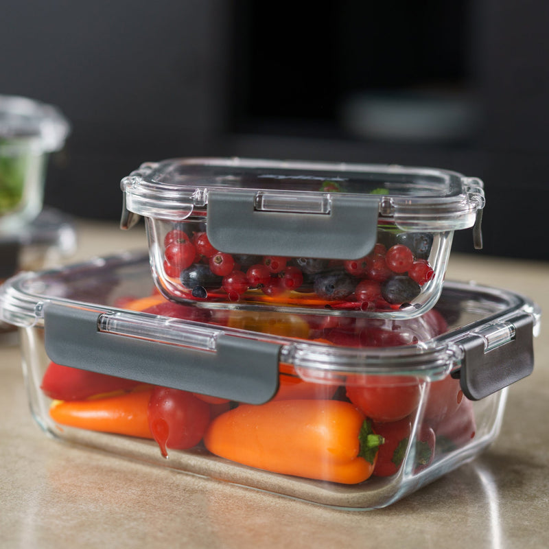 Glass food storage containers with vegetables on a wooden surface