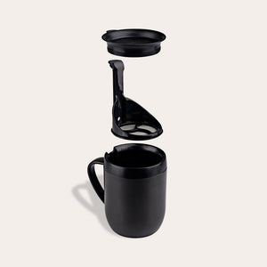 The Zyliss Hot Mug Cafetière Mug is shown with its double-wall insulated mug, removable filter, and lid arranged vertically—ideal for coffee lovers—all set against a plain light background. #grey