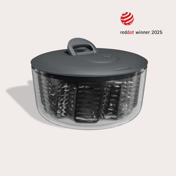 #large  A transparent Zyliss Easy Spin Salad Spinner with a dark gray lid and handle is shown, featuring AquaVent technology and a circular design. The image displays the â€œRed Dot Winner 2025â€ award logo in the corner.