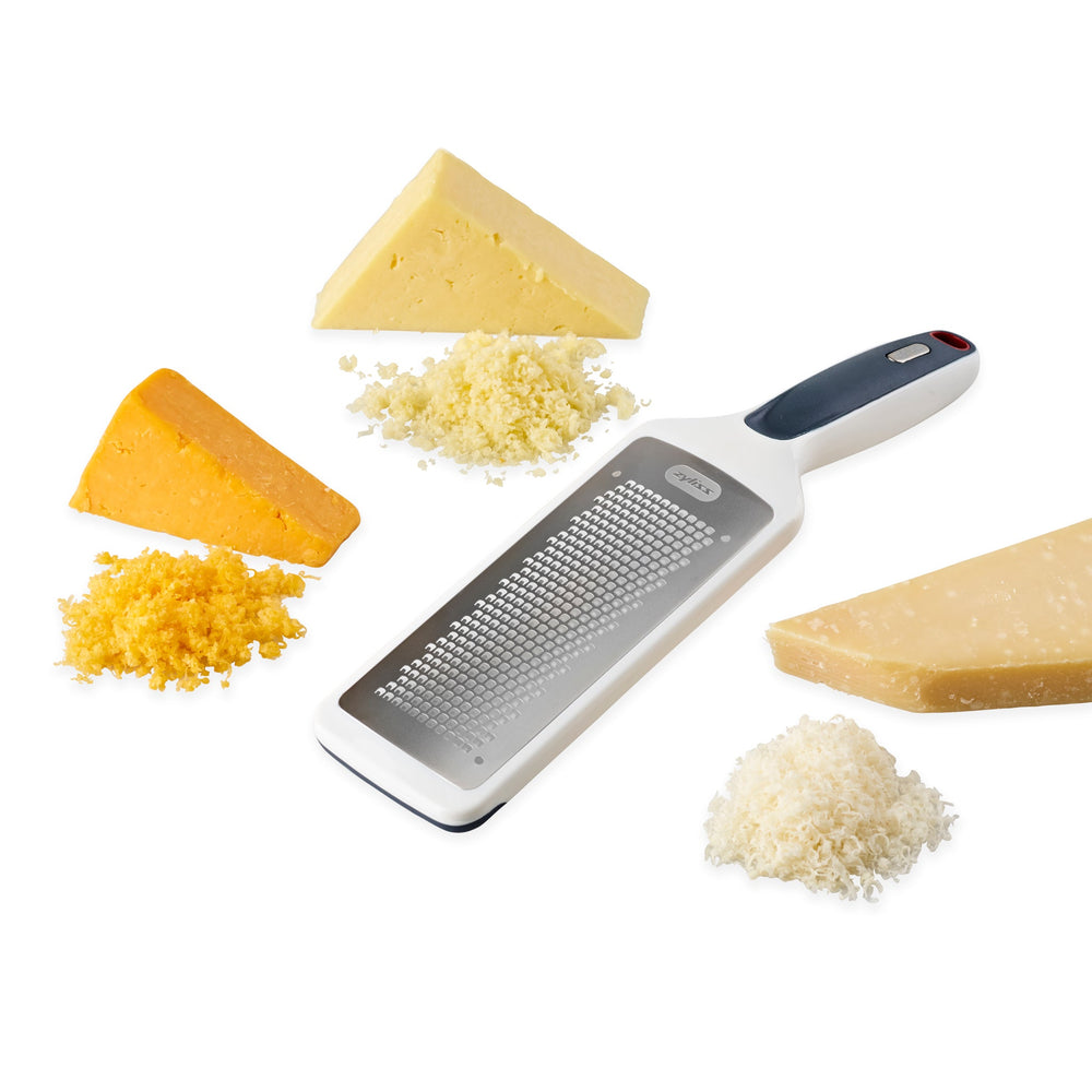 The Zyliss Smooth Glide Fine Grater features a stainless steel blade and an ergonomic black and gray handle, ideal for grating cheese, vegetables, or zesting lemons. Pictured here against a plain white background. 