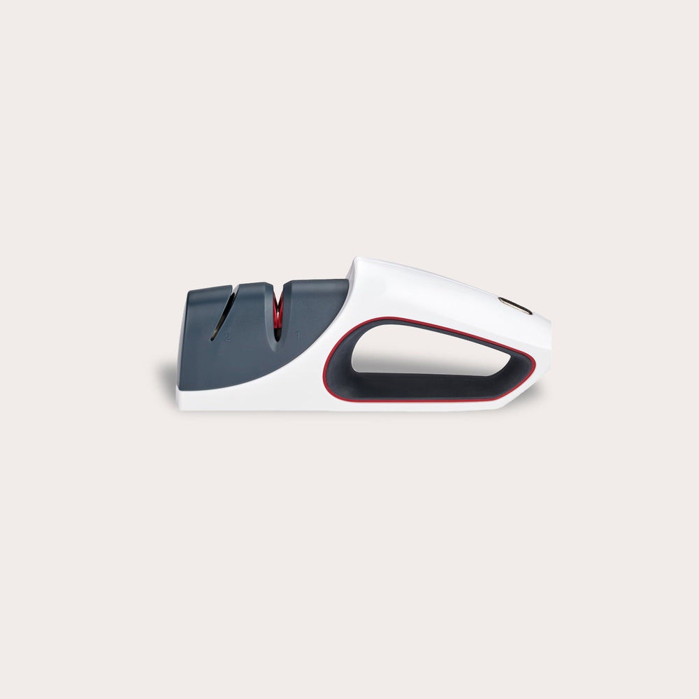 The Zyliss Control Knife Sharpener is a modern handheld sharpener for kitchen knives, featuring a white and gray body with red accents, two sharpening slots (including ceramic), shown against a plain light background. 