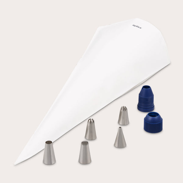 The Zyliss Reusable Piping Bag Kit features a white silicone bag, five stainless steel nozzles, and two blue couplers—ideal for cake decorating and easy to reuse. 