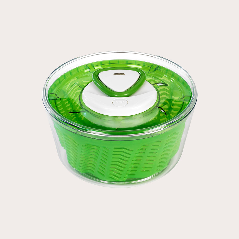 The Zyliss Easy Spin 2 Salad Spinner Small is green and transparent with a compact design, featuring a white button and handle on top, shown from above against a plain light background. 