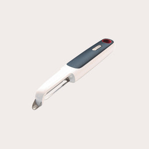 The Zyliss Smooth Glide Swivel Peeler features an ergonomic white handle with a black grip, stainless steel blades, and a red accent at the end, displayed against a plain light background. 