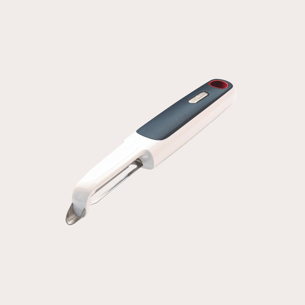 The Zyliss Smooth Glide Swivel Peeler features an ergonomic white handle with a black grip, stainless steel blades, and a red accent at the end, displayed against a plain light background. 