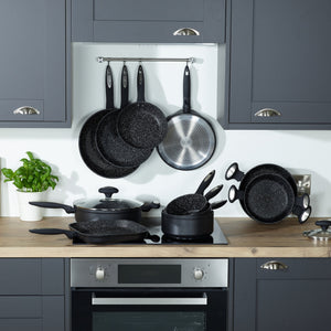 A modern kitchen with grey cabinets, a wooden countertop, and Zyliss Ultimate Non-Stick Frying Pans with Swiss coating in black speckle displayed on the stove and wall. A potted basil plant adds a touch of green on the counter. #20cm/8"