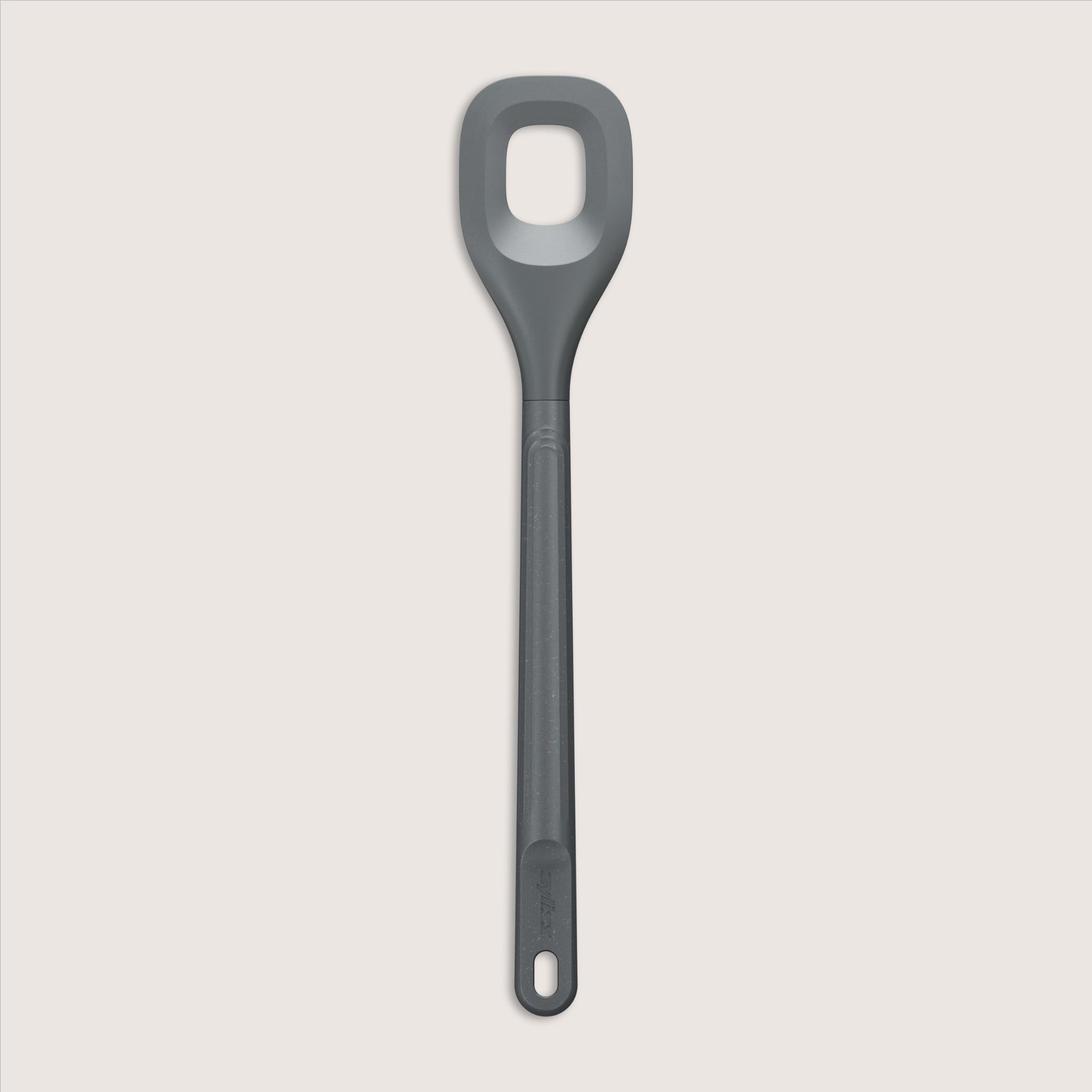 A gray silicone spoon with a rectangular hole in the center of the head and a long handle, set against a plain, light background.