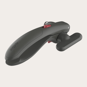 A dark gray ergonomic tool with a textured finish, featuring a small red button and a silver metal ring, shown on a solid white background.