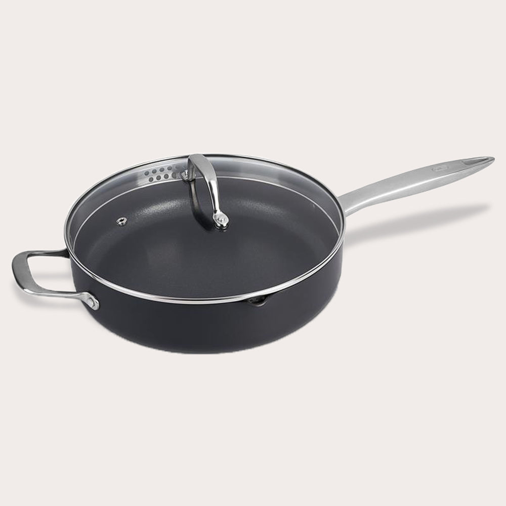 The Zyliss Ultimate Pro Non-Stick Saute Pan & Glass Lid features PFOA-free, hard-anodized aluminum, a long handle, and a side handle, all displayed on a plain light background. 