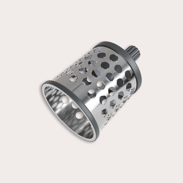 The Zyliss Puree Drum Gourmet, a stainless steel rotary grater attachment featuring large circular and oval holes, is designed for use with kitchen appliances and displayed on a plain light background. 